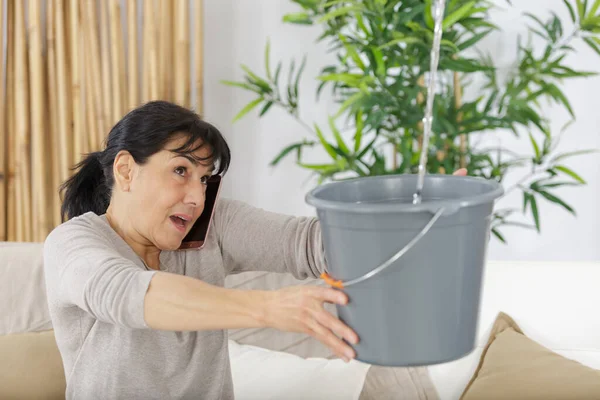 Besorgte Frau Ruft Klempner Während Sie Wasser Von Der Decke — Stockfoto