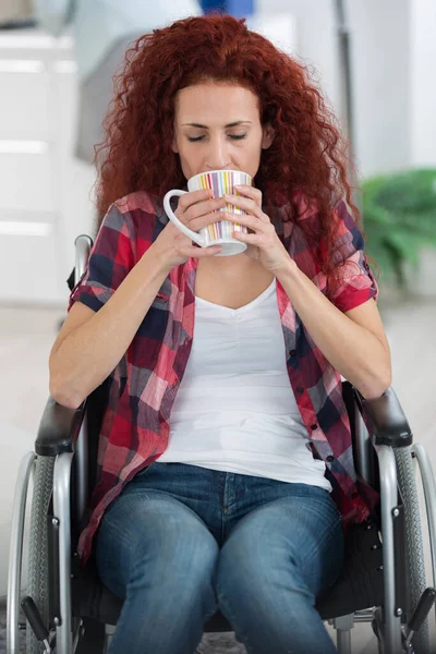 Γυναίκα Κάθεται Αναπηρική Καρέκλα Στο Σπίτι Πίνοντας Τσάι — Φωτογραφία Αρχείου