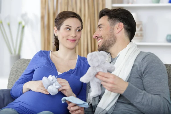 Loving Future Parents Sofa Holding Booties Soft Toy — Stock Photo, Image