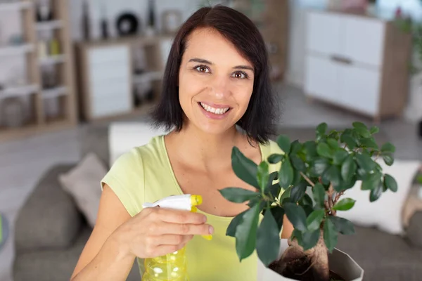 幸せな女が盆栽に水を吹きかける — ストック写真