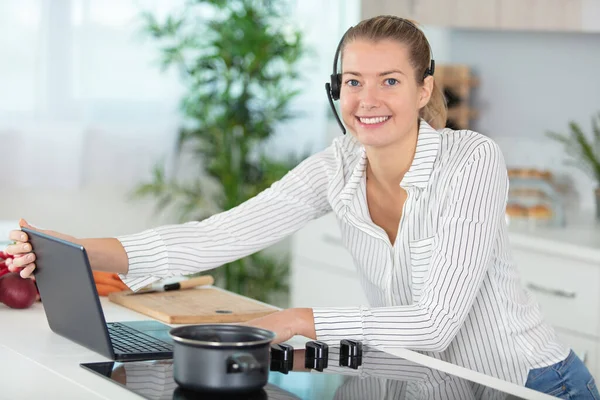 Mujer Multitarea Está Cocinando Mientras Usa Auriculares Uso Ordenador Portátil —  Fotos de Stock
