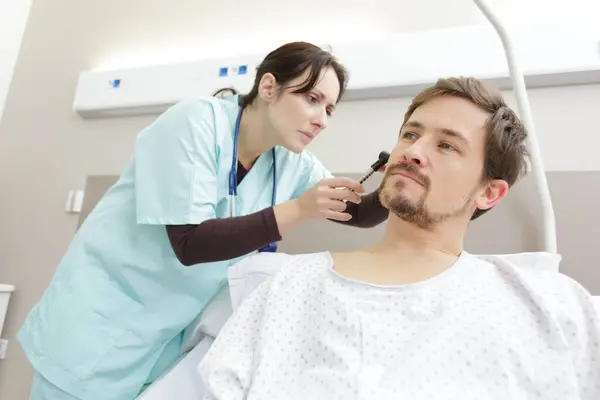 男病人用耳镜检查她的耳朵 — 图库照片