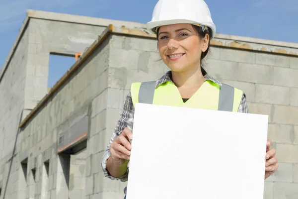 Female Worker Wearing Hard Hat Holds White Banner — Stockfoto