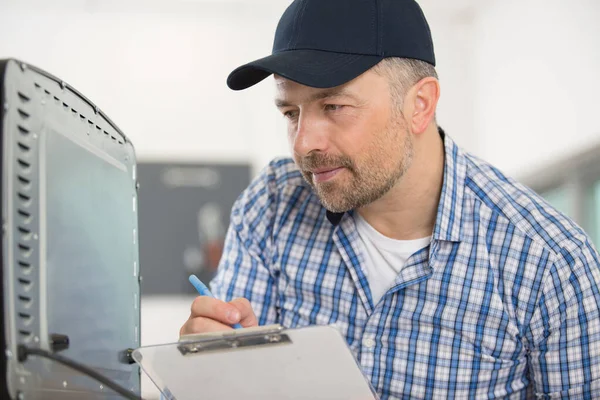 Serviceman Writing Appliance Serial Number His Paperwork — Stock Photo, Image