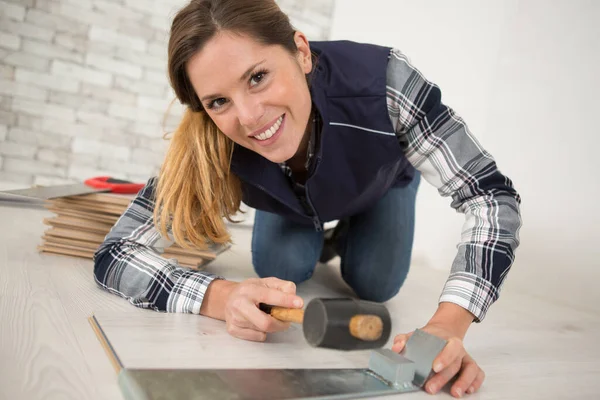 Αρκετά Χαρούμενη Γυναίκα Εγκαθιστώντας Πλαστικοποιημένο Πάτωμα Ένα Σφυρί — Φωτογραφία Αρχείου