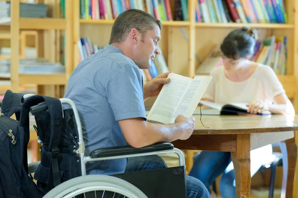 公共图书馆坐轮椅的中年男子 — 图库照片