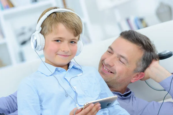 Πατέρας Και Παιδί Χαλαρώνουν Στον Καναπέ Φορώντας Ακουστικά — Φωτογραφία Αρχείου