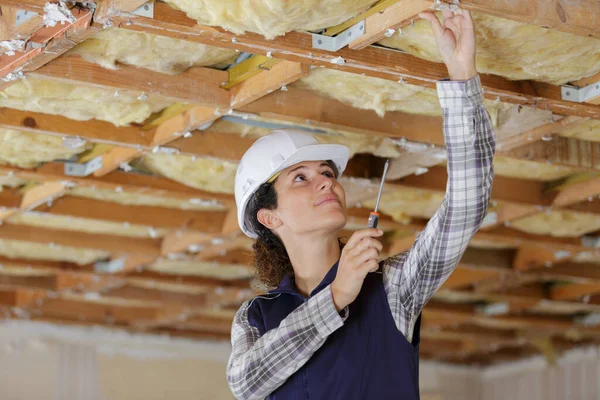 在天花板上工作的年轻女建筑工人 — 图库照片