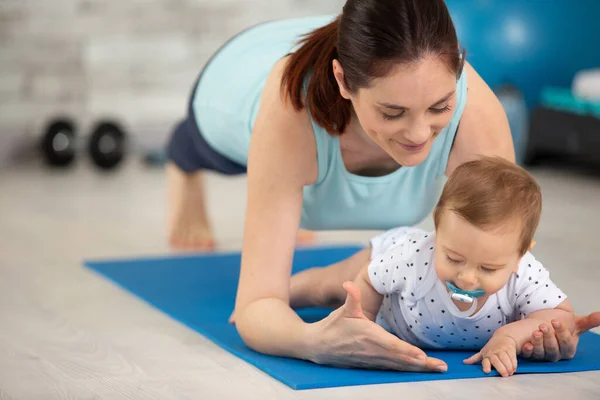 Atletik Anne Bebekle Tahta Pozisyonunda Egzersiz Yapıyor — Stok fotoğraf