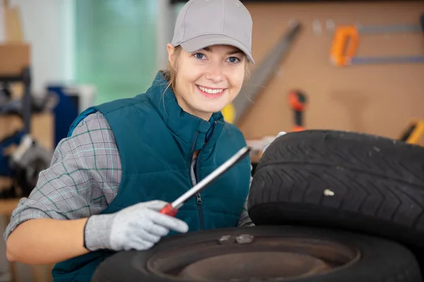 Pretty Girl Reparing Car Tyre Garage — Stock Photo, Image