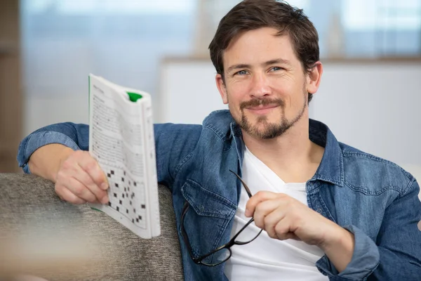 Young Man Sitting Doing Crossword Puzzle — Stock Photo, Image