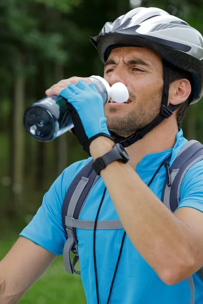 骑自行车的人停下来喝水 免版税图库图片