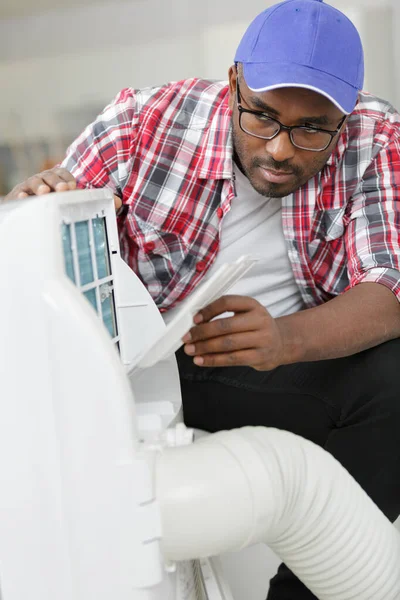Male Technician Cleaning Air Conditioner Indoors — Stock Photo, Image