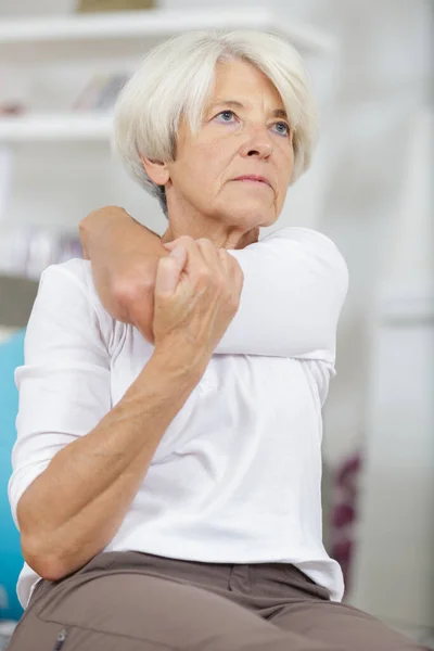 Senior Vrouw Doet Een Schouder Stretch — Stockfoto