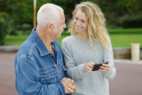 Mulher Mostrando Tela Smartphone Para Seu Pai — Fotografia de Stock