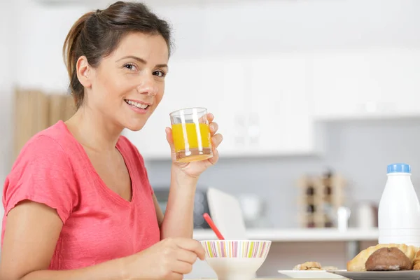 Γυναίκα Πίνοντας Χυμό Πορτοκαλιού Στην Κουζίνα — Φωτογραφία Αρχείου