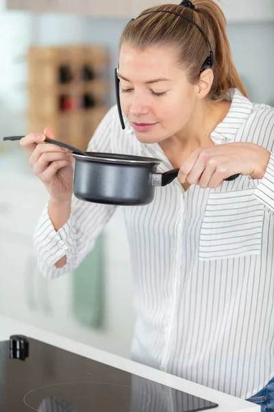 女性臭い食べ物で鍋に身に着けている間フリーヘッドセット — ストック写真