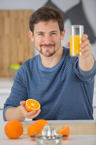 微笑的男人拿着一杯新鲜橙汁 — 图库照片