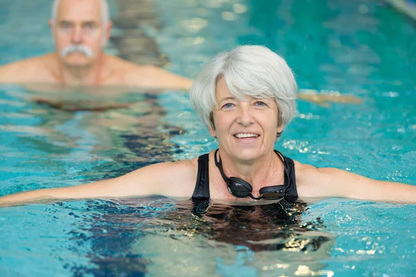 健康活泼的老年妇女在游泳池里游泳 — 图库照片