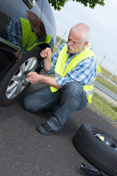 Hombre Anciano Cambiando Neumático Que Gotea Borde —  Fotos de Stock