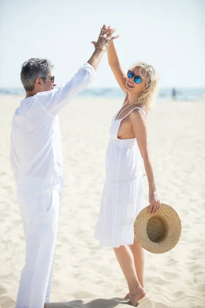 一对成熟的夫妇在海滩上快乐而悠闲地跳舞 — 图库照片