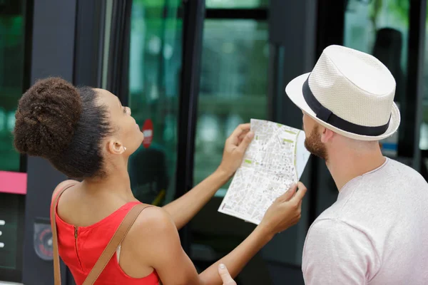 幸せな観光客が地図をチェックし — ストック写真