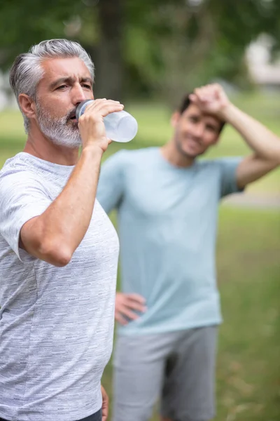 Homens Bebendo Água Uma Garrafa Fora — Fotografia de Stock
