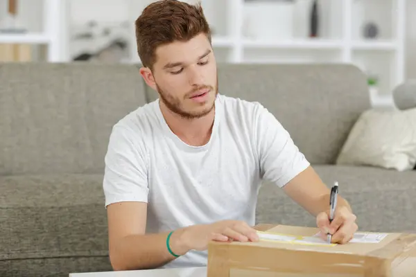 Mann Schreibt Notiztext Auf Verpackungskiste — Stockfoto