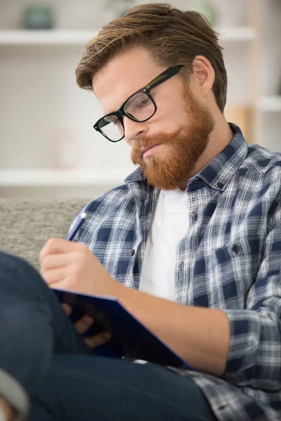 Homme Intelligent Écrivant Dans Livre Assis Sur Canapé — Photo