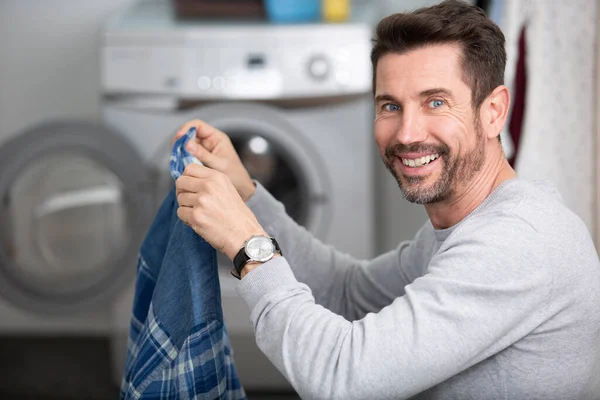 Mutfaktaki Çamaşır Makinesine Çamaşır Yükleyen Mutlu Adam — Stok fotoğraf