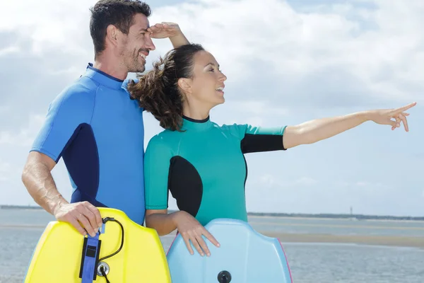 Pareja Con Bodyboards Apuntando Distancia — Foto de Stock