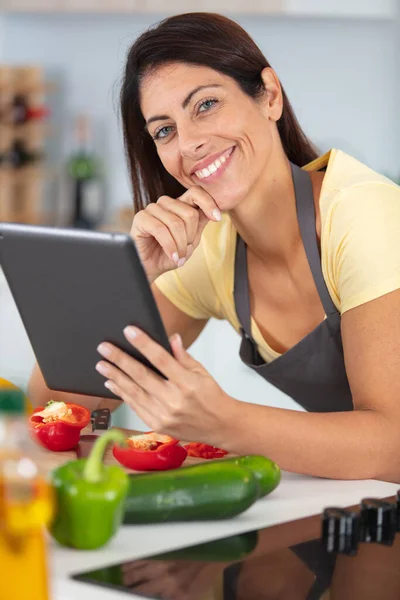 做饭时阅读平板电脑食谱的女人 — 图库照片