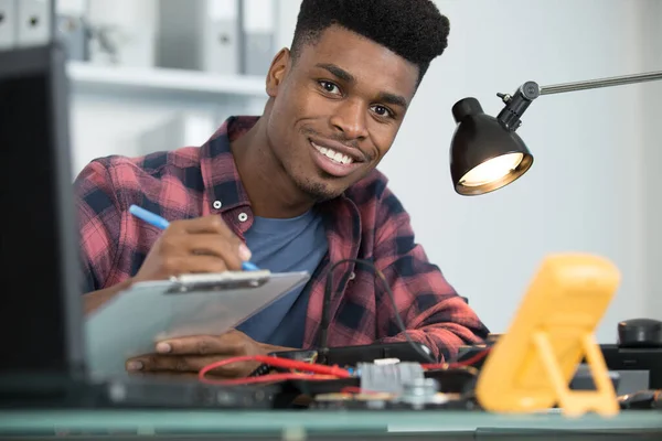 Engineer Taking Notes While Fixing Computer — Stock Photo, Image