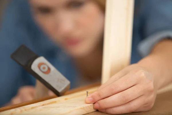 木枠に釘を打って女性大工 — ストック写真