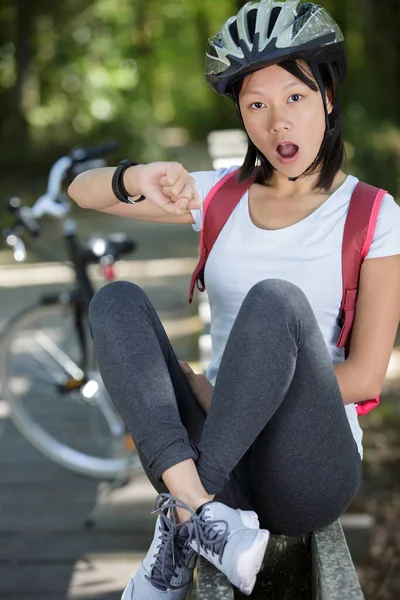 ショックを受けて腕時計を見ている女性のアジア人サイクリストは — ストック写真