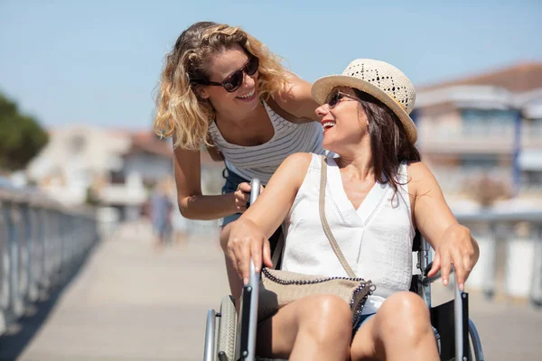 无效的女孩在轮椅上的和户外活动的朋友 — 图库照片