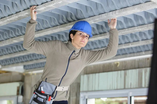 Kvinnlig Byggnadsarbetare Kontrollerar Tak — Stockfoto