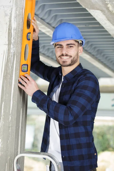 Young Man Builder Worker Uses Magnetic Level — Stock Photo, Image