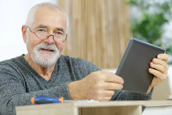 Χαμογελαστός Ηλικιωμένος Άνδρας Που Χρησιμοποιεί Ψηφιακό Tablet Για Χτίσει Ένα — Φωτογραφία Αρχείου