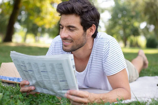 Man Die Een Krant Leest Terwijl Hij Een Groene Weide — Stockfoto