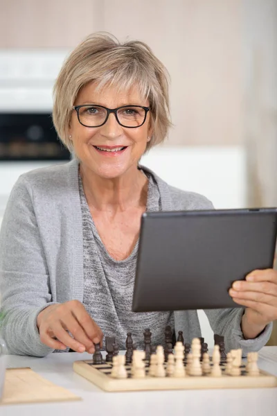 Starsza Kobieta Gra Szachy Trzyma Tablet — Zdjęcie stockowe