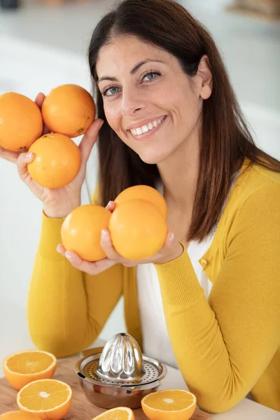 漂亮的黑头发女人 手里拿着多汁的 美味的橙子 — 图库照片