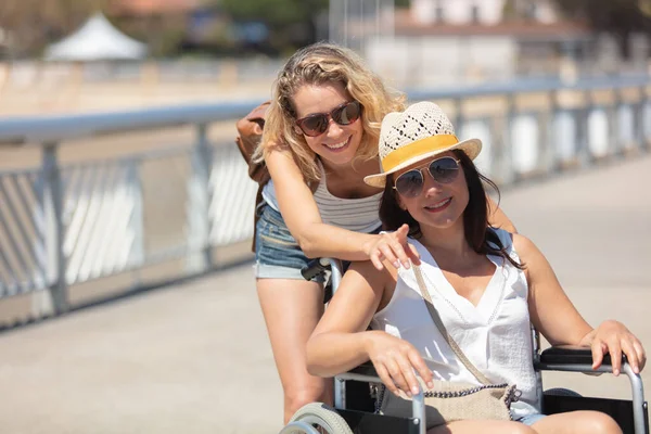 Kobieta Wózku Inwalidzkim Radosny Przyjaciel Nad Morzem — Zdjęcie stockowe