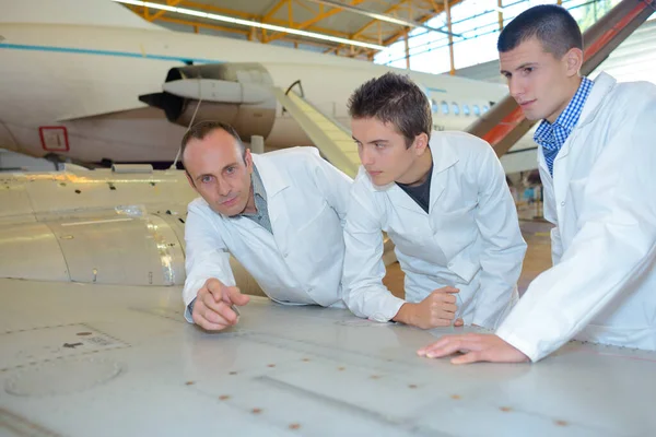 若い技術者が航空機システムをチェックし — ストック写真