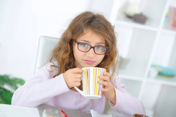 young girl drinking hot beverage