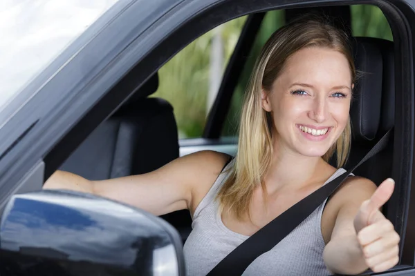 快乐的年轻女人竖起大拇指的车 — 图库照片