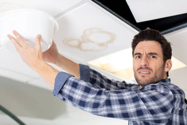 Stressed Man Holding Bowl Leaking Ceiling — Stock Photo, Image