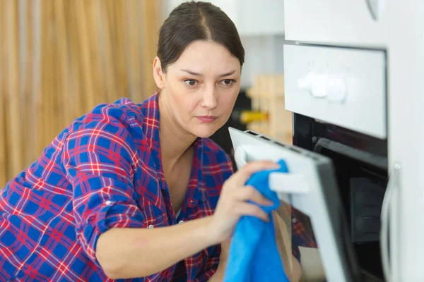 女人用抹布清洗烤箱 — 图库照片