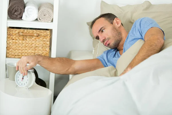 Yatakta Bir Adam Çalar Saati Kapatırken Çekiyor — Stok fotoğraf