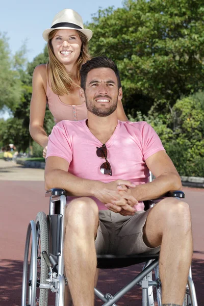 坐在轮椅上在公园里散步的幸福夫妻 — 图库照片